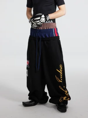 Black triple waist track flares with layered elastic waistband and oversized puddle leg streetwear outfit front view