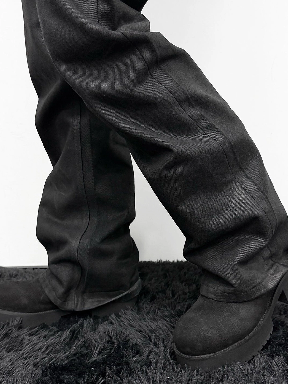 Low side close-up of black tumbled leather slouch mid-calf boots with thick molded platform outsole