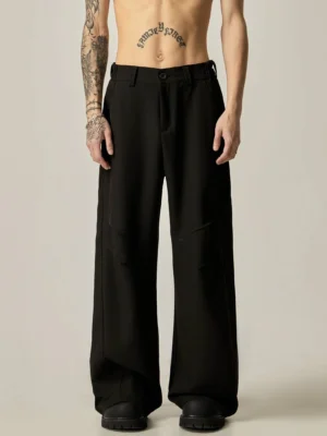 Black ultra-wide leg tailored trousers front full body view showing fluid oversized dress pant silhouette and button waist closure