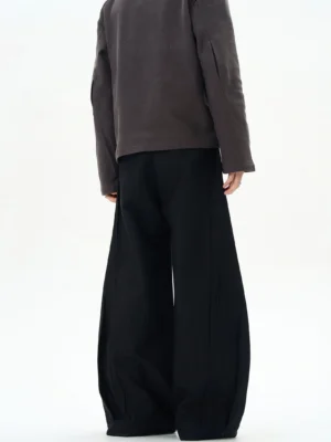 Black ultra-wide tailored trousers shown from the back with an exaggerated wide-leg silhouette and structured side seams