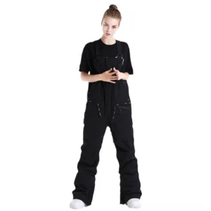 Black unisex techwear bib snow pants shown in a full front studio view with adjustable shoulder buckles, relaxed straight legs, zippered cargo pockets, and insulated winter utility construction