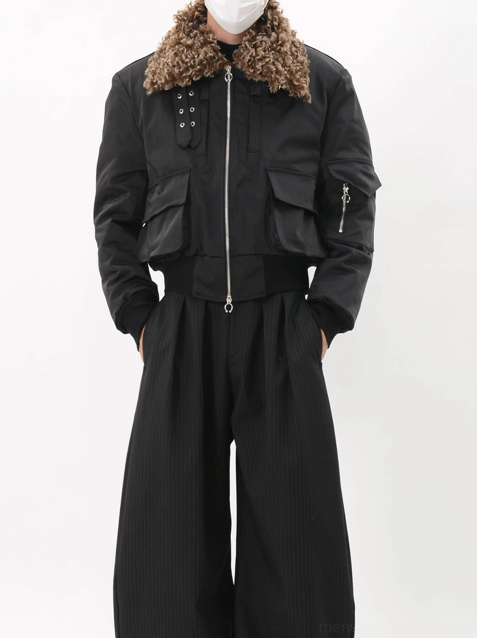 Front half-body view of a black utility bomber jacket for men featuring a plush brown faux fur collar, metal front zipper, snap details and ribbed hem