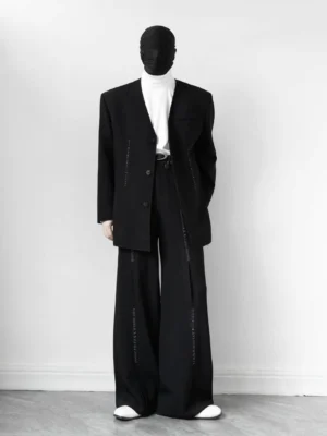 Front view of black V-neck blazer and wide-leg trouser suit with exposed seam details and relaxed streetwear fit