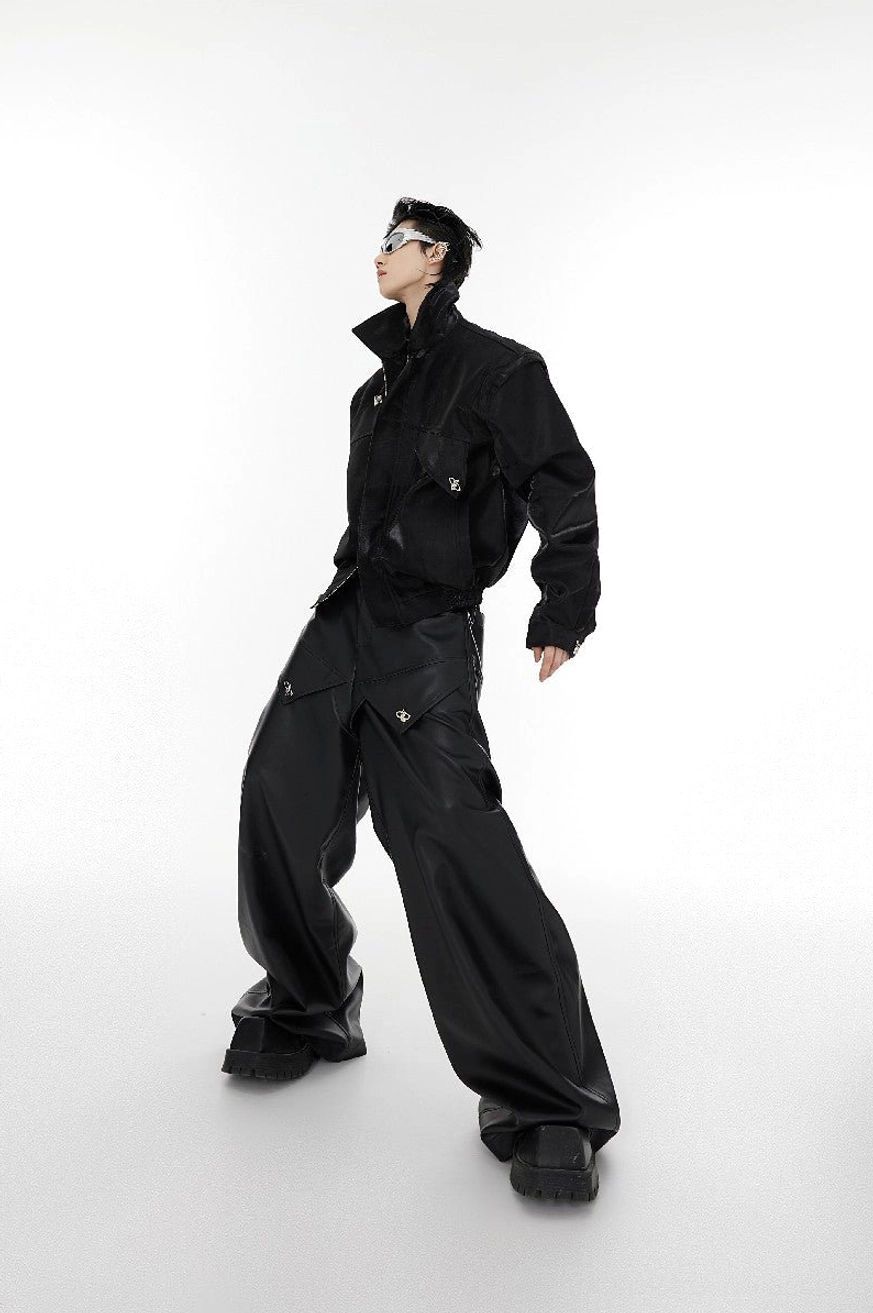 Black vegan leather cropped streetwear jacket side view featuring padded shoulders, metal buckles and oversized silhouette