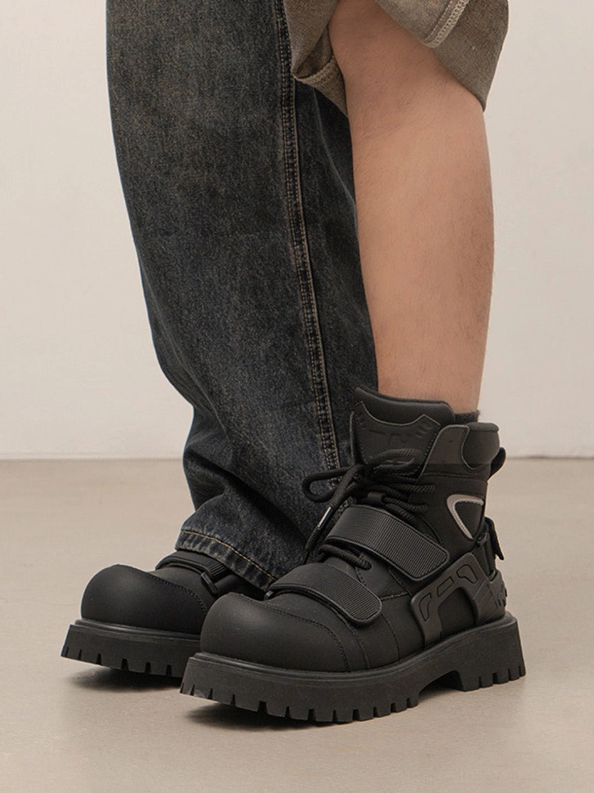 Black Velcro strap lug sole moto combat boots technical streetwear footwear detail view