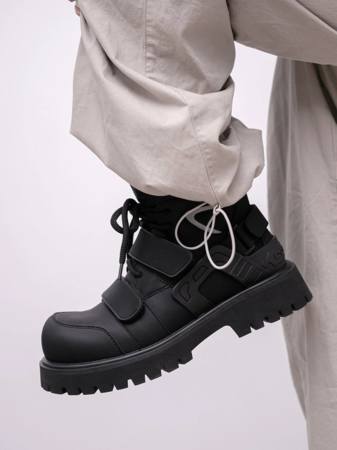 Black high-top moto combat boot with lace-up front Velcro straps and chunky platform lug sole