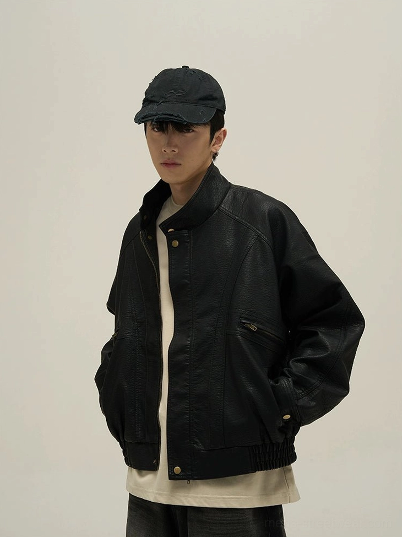 Black vintage faux leather stand collar bomber jacket front three-quarter view on male model with black cap