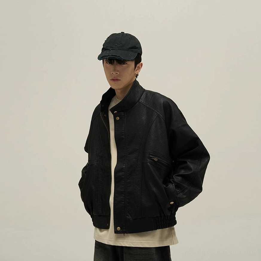 Black vintage faux leather stand collar bomber jacket low front three-quarter view on male model with hands in pockets