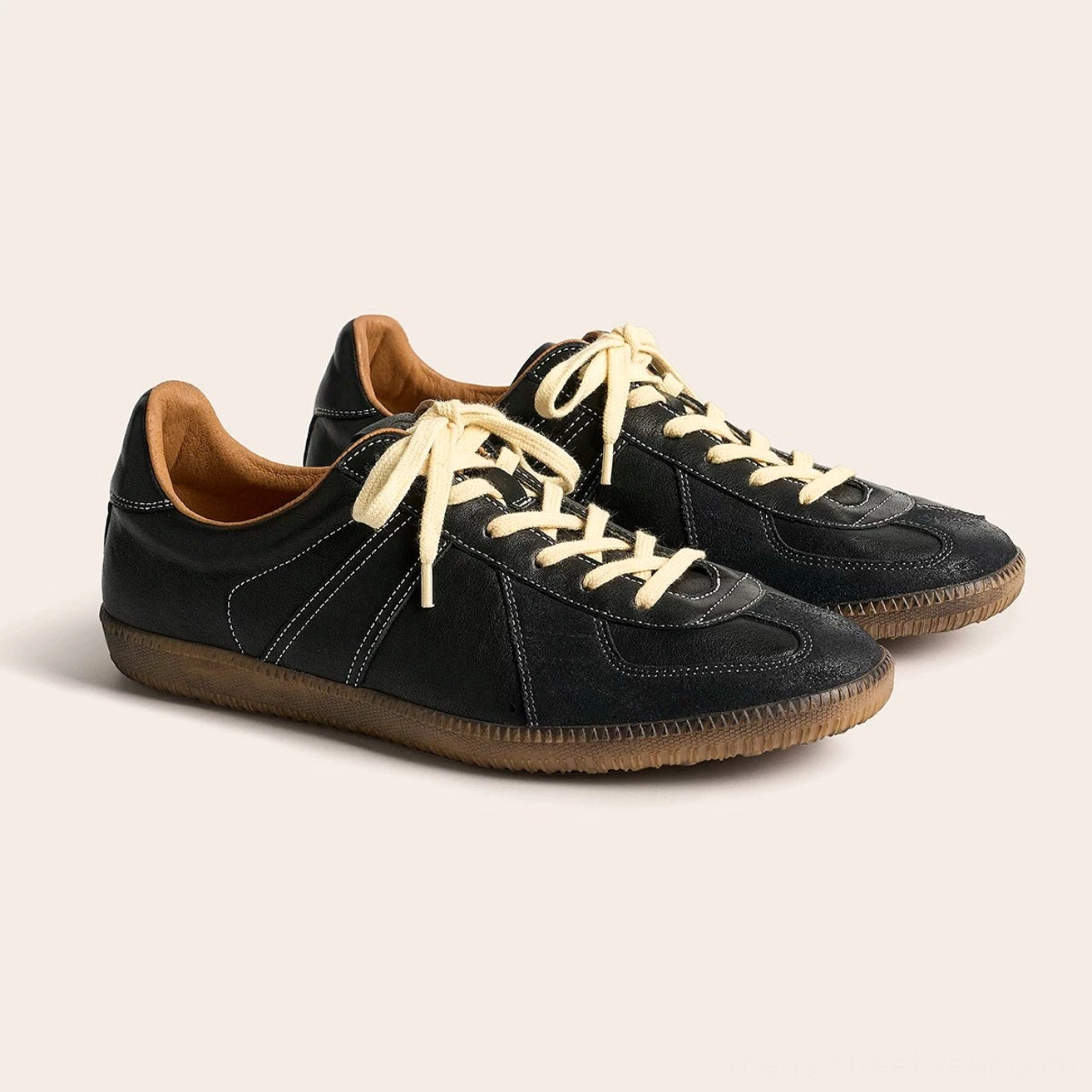 Pair of black vintage leather German Army Trainer sneakers with off-white laces in three-quarter view