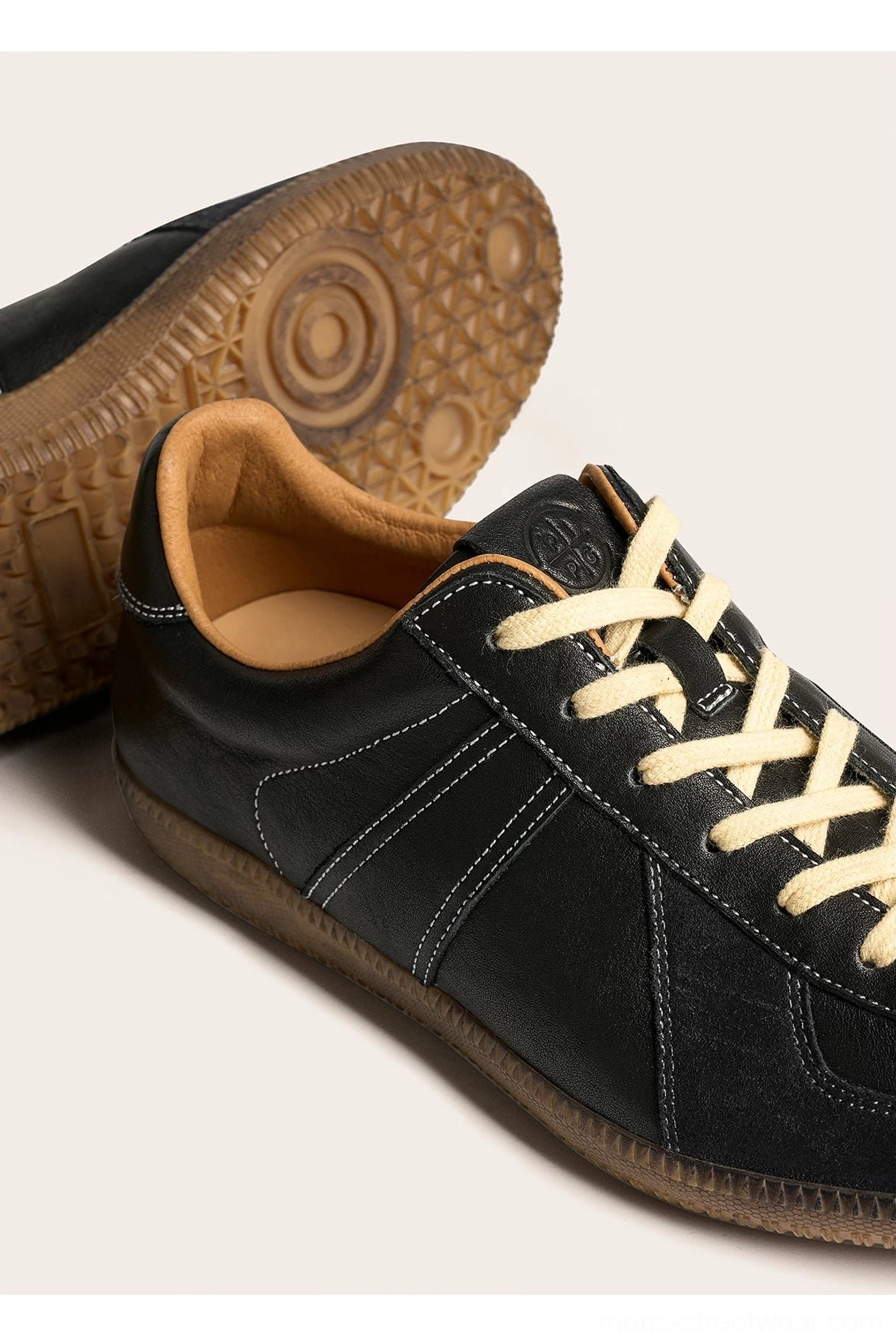 Close-up of black vintage leather sneaker side stitching gum rubber outsole and tan collar lining