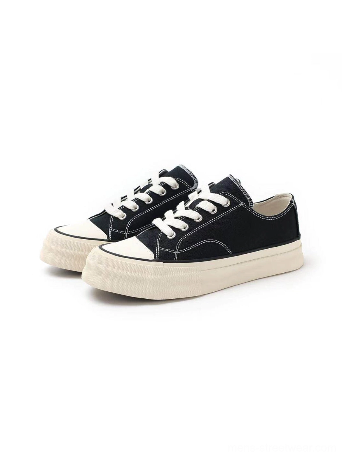 Front three-quarter view of black vulcanized canvas platform sneakers with wide laces and rubber toe caps