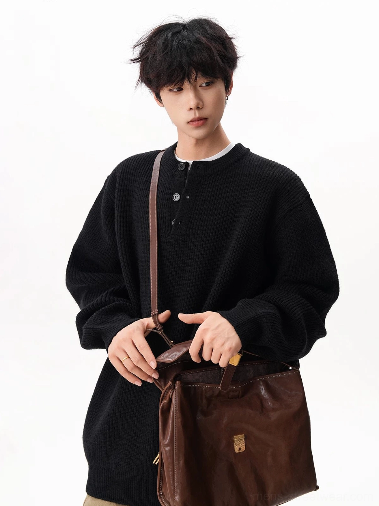 Black oversized waffle Henley knit sweater styled with khaki wide-leg pants and a large brown leather tote bag