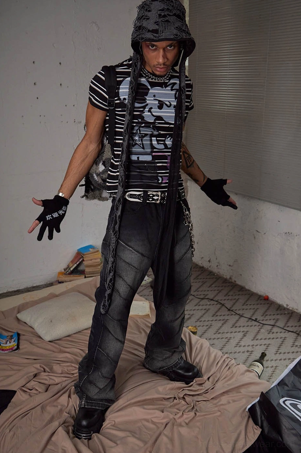 Dynamic front view of black washed flared jeans with metal chain accessory and angular seam detailing