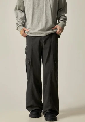 Front detail of black washed cotton wide leg cargo pants with button waistband and dual side cargo pockets for modern streetwear styling