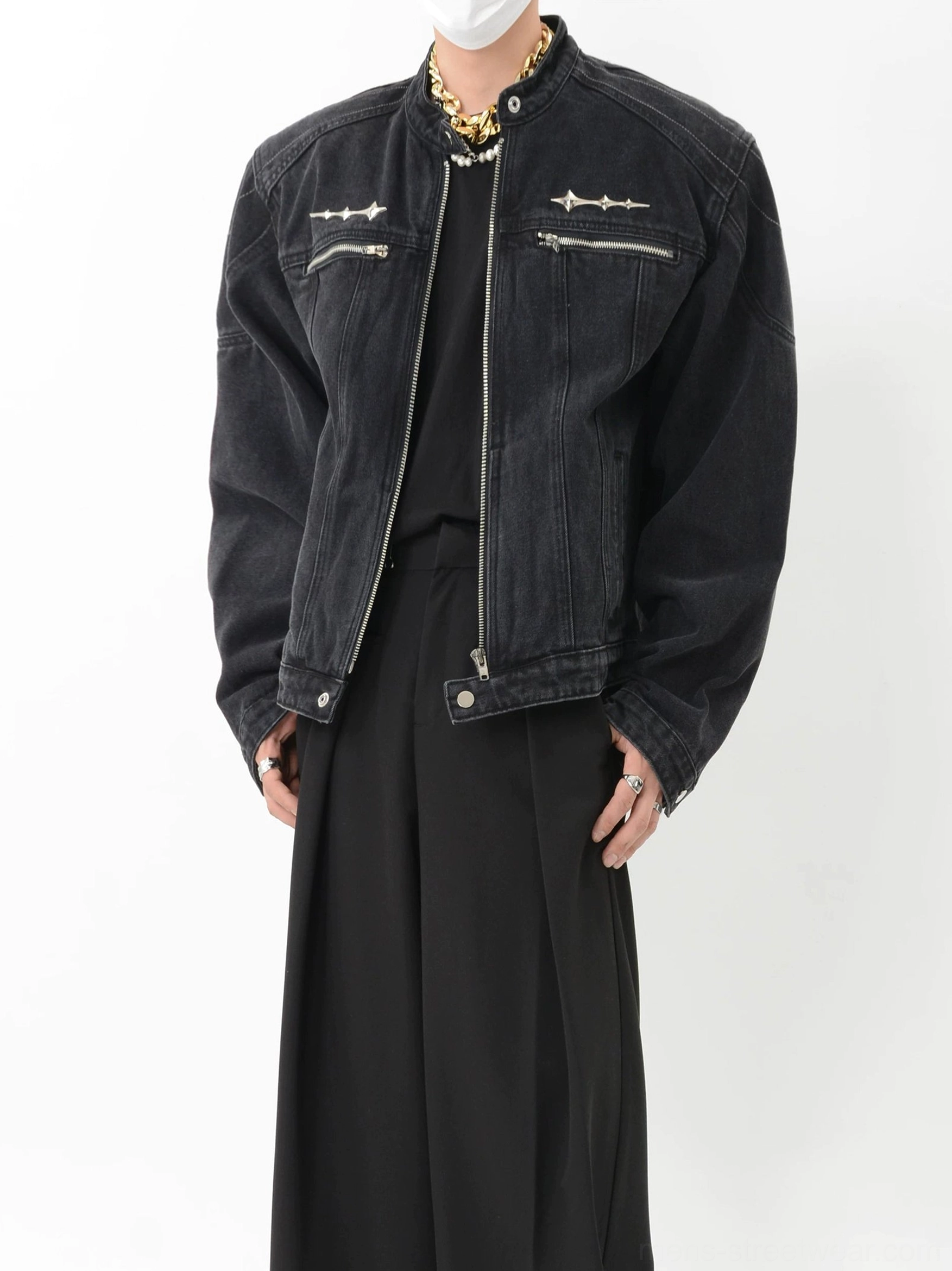Close up of black washed denim streetwear moto jacket with silver spike hardware panel stitching and short stand collar