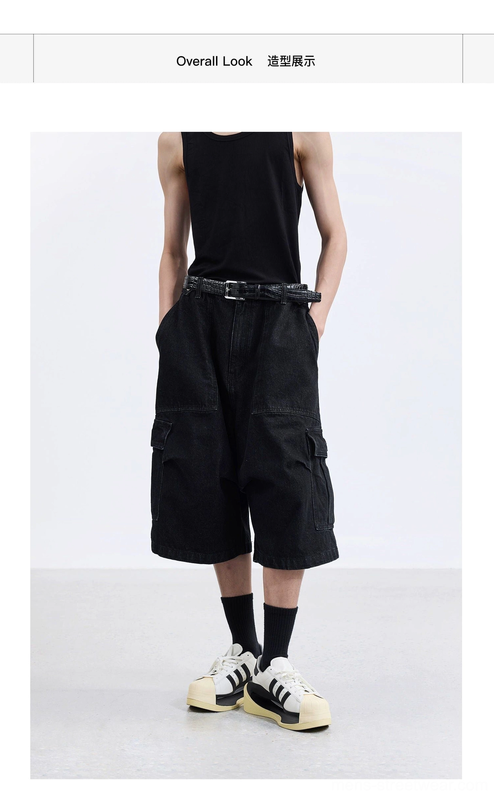 Black washed denim wide-leg cargo capri shorts on male model with black tank top belt sneakers and oversized utility pockets full body view