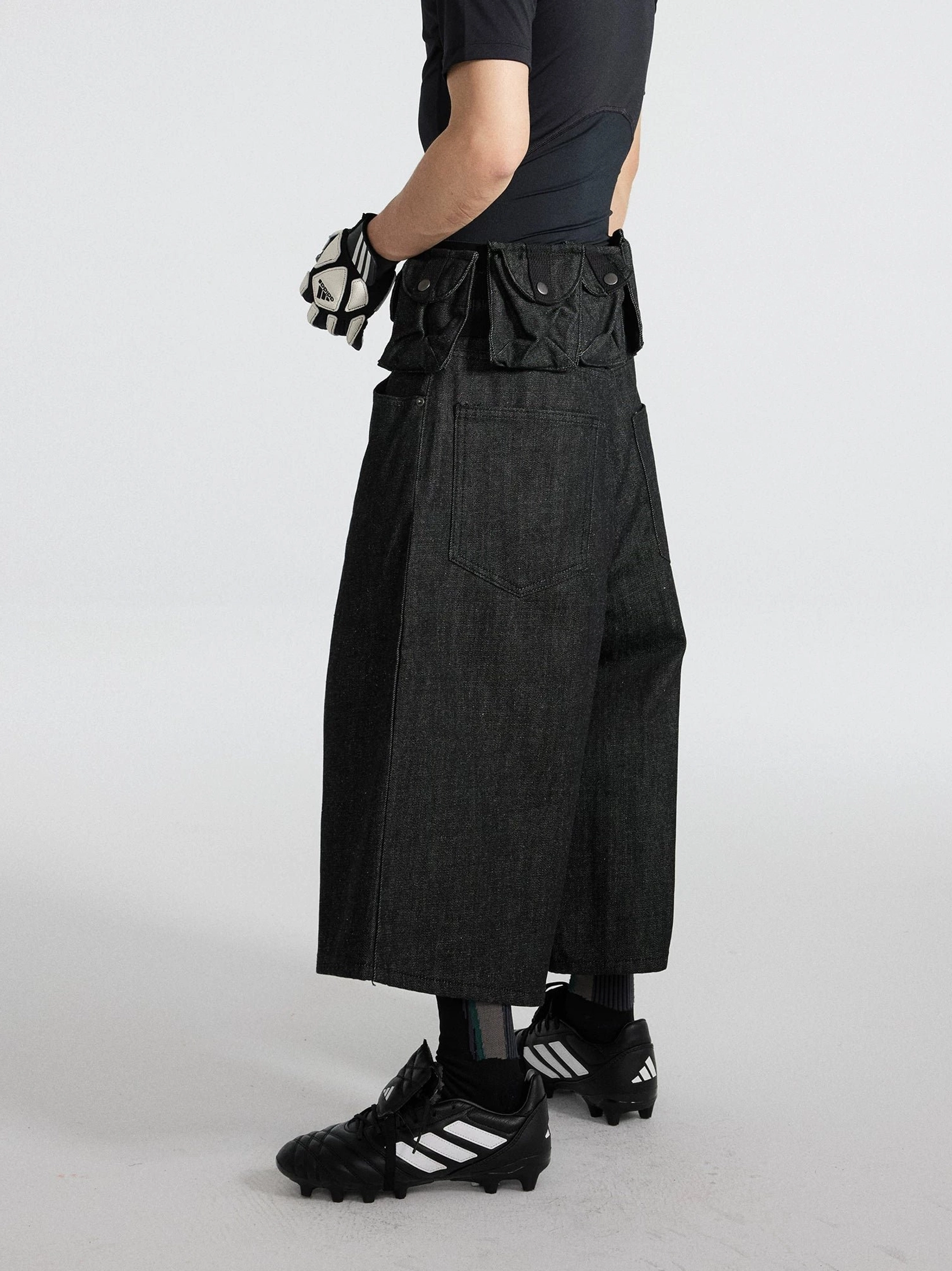 Black washed denim wide-leg cargo cropped shorts side profile showing relaxed below-knee streetwear fit