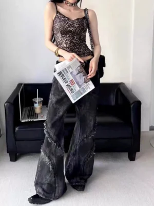 Front view of black washed distressed flared jeans featuring diagonal frayed seam details, wide-leg flare silhouette, and vintage streetwear styling