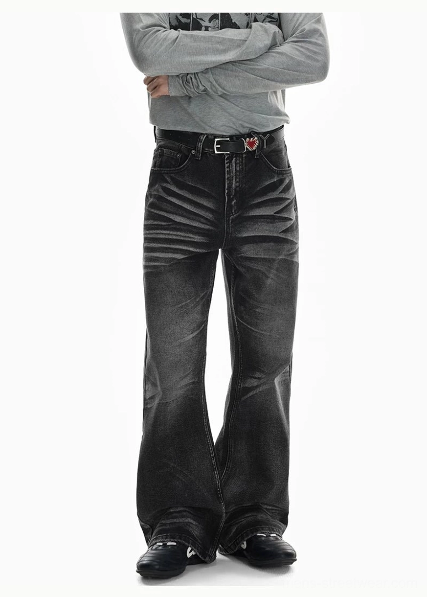 Front view of black washed flare jeans with crease fading, relaxed wide-leg proportions, five-pocket denim construction, and a bold retro streetwear shape