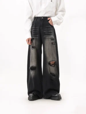 Black washed heavily ripped extra wide leg streetwear jeans front three-quarter view with faded grey denim and raw frayed distressing