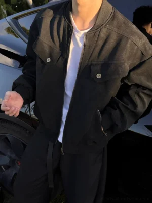 Close-up front view of black washed retro bomber jacket with zipper closure ribbed collar and relaxed Korean streetwear fit