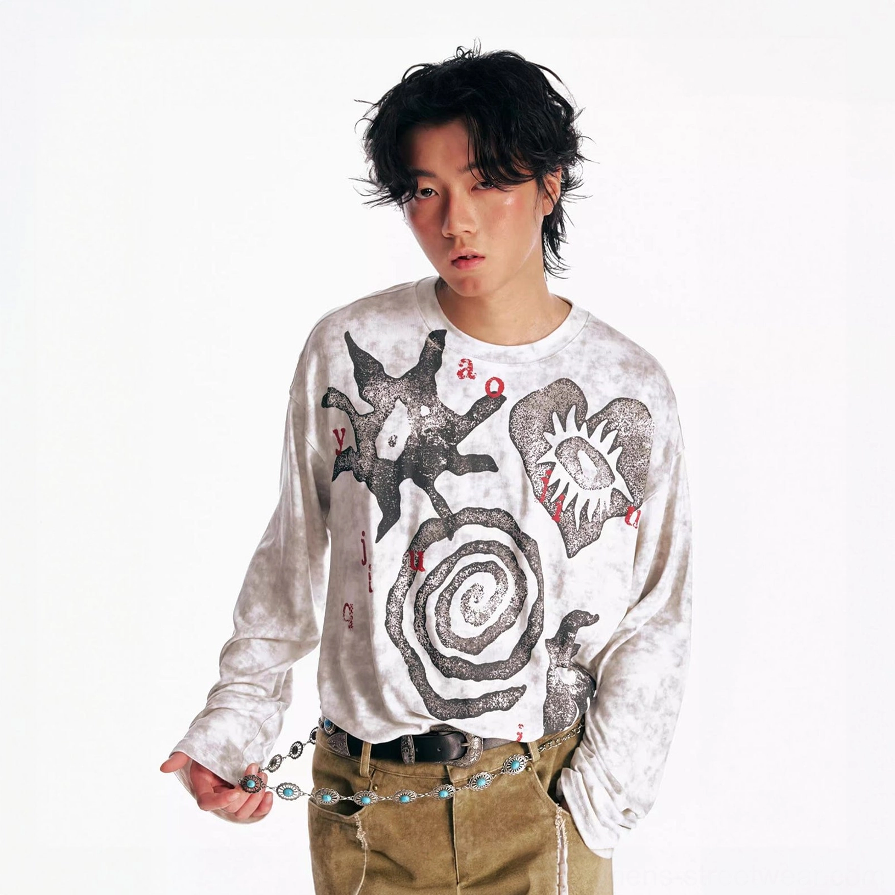 Black washed tribal graphic oversized long sleeve tee on male model styled with khaki cargo pants and chain belt