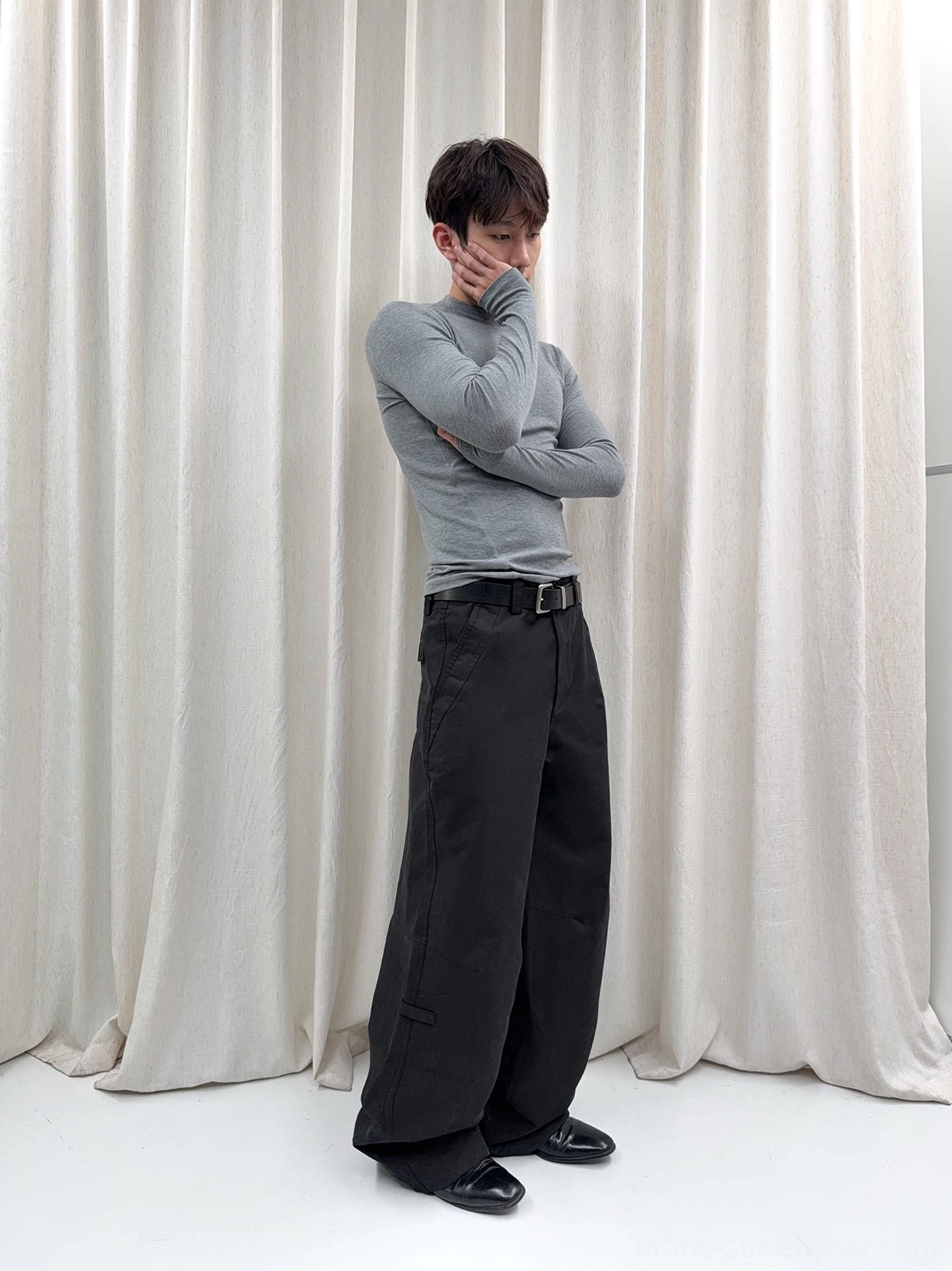 Black washed wide-leg cotton trousers shown from the side with a neat waistband, belt styling, and modern Seoul streetwear proportions