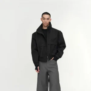 Men's black water-repellent padded stand-collar cropped utility jacket with dual flap pockets and ribbed cuffs styled with wide-leg streetwear trousers