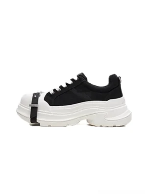 Black and white buckle platform canvas sneaker left side view with silver toe strap, white laces, black upper, and chunky wave sole