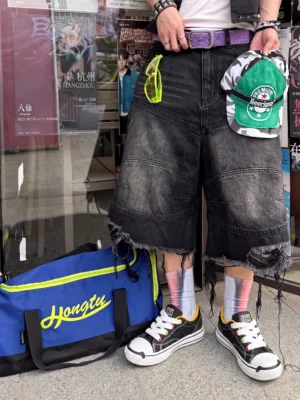 Black and white cartoon cat chunky sneakers styled with ripped denim shorts and colorful socks in an urban street setting