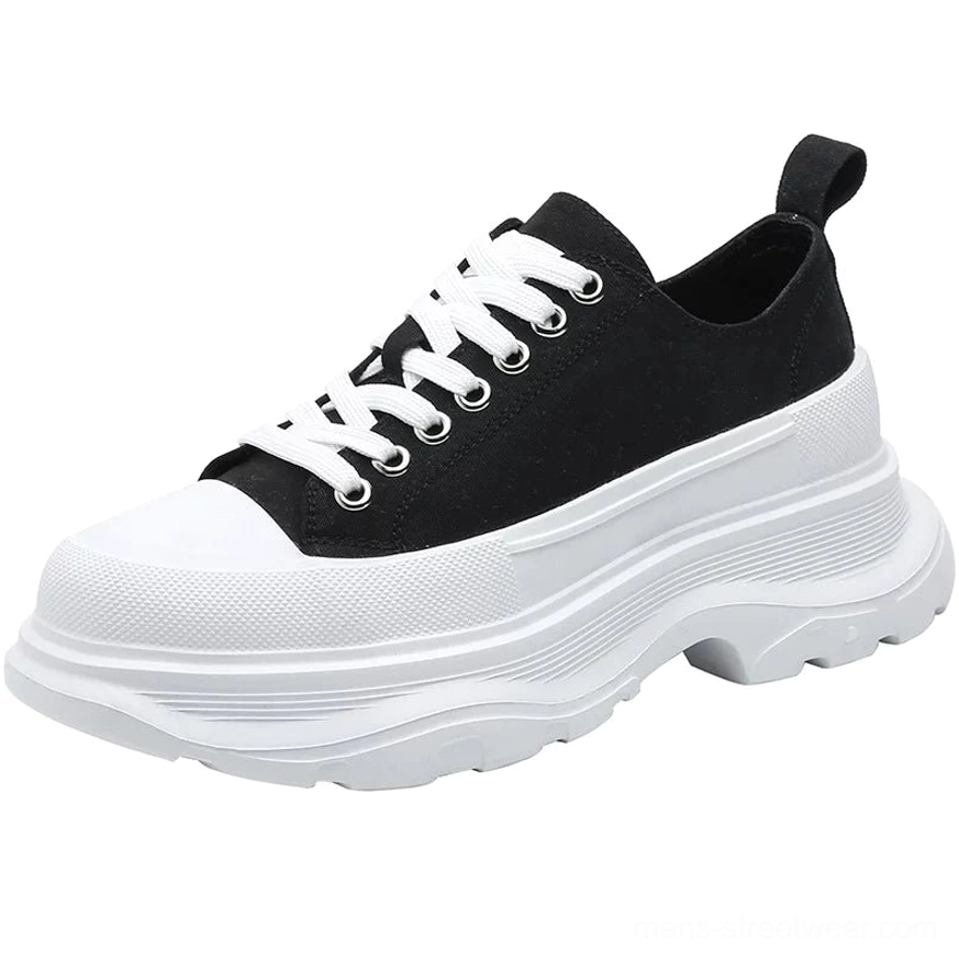 Single black and white chunky platform canvas sneaker side view with white toe cap heel pull tab and lace-up closure