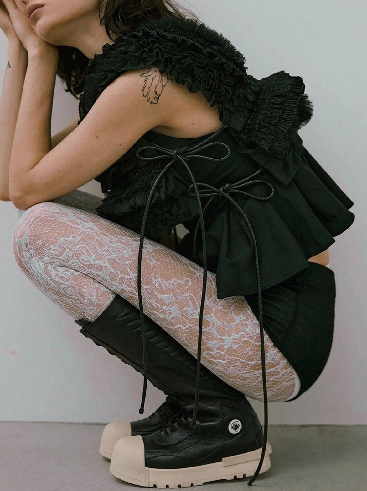 Model wearing black and white contrast toe mid-calf platform boots with lace tights in a dark romantic streetwear outfit