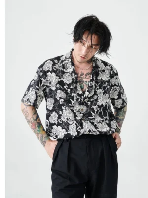 Black and white floral Hawaiian streetwear shirt worn with black high waisted trousers in a three quarter front view