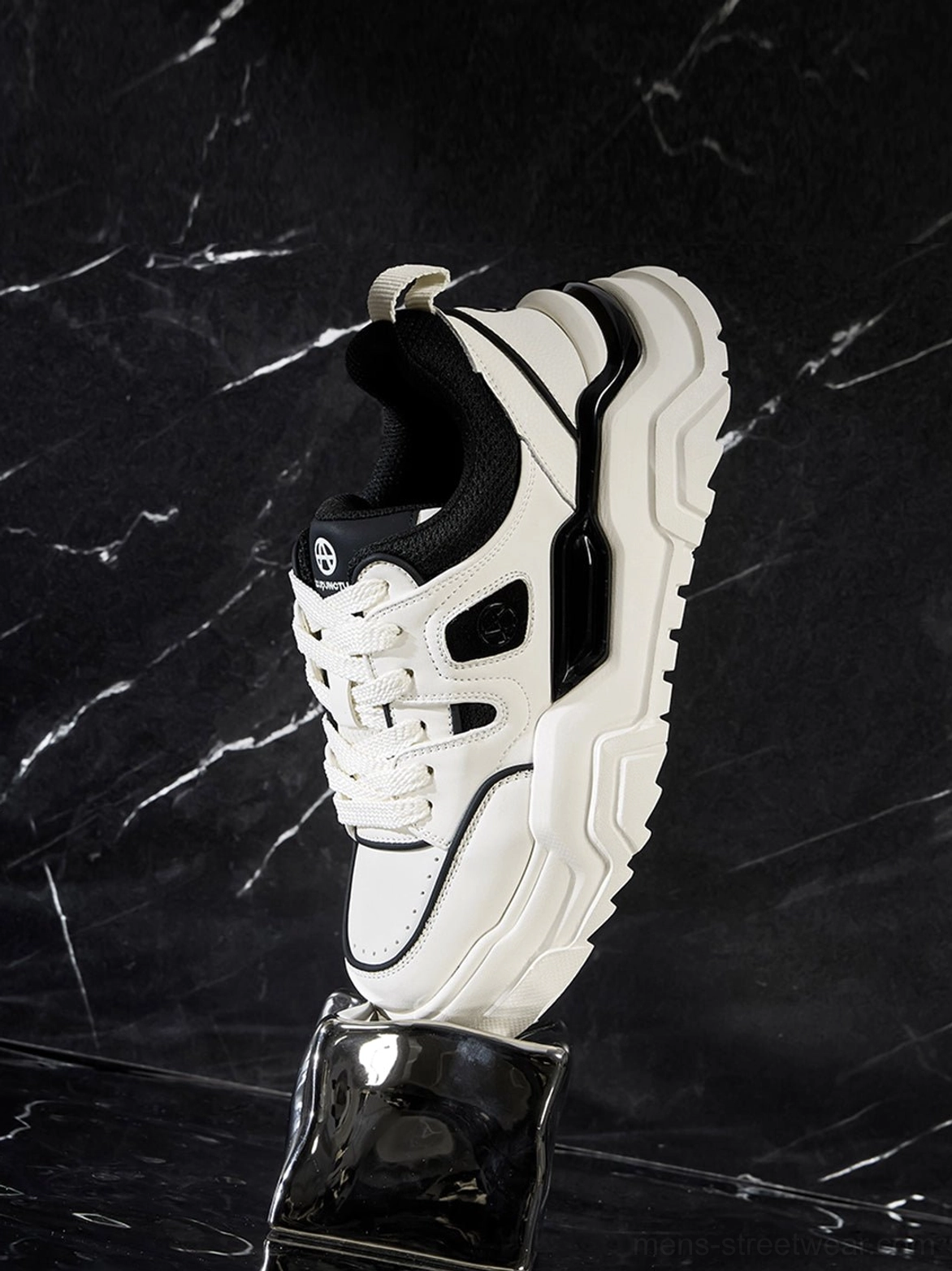 Black and white geometric platform sneaker three-quarter view emphasizing architectural cutout panel design and platform sole elevation