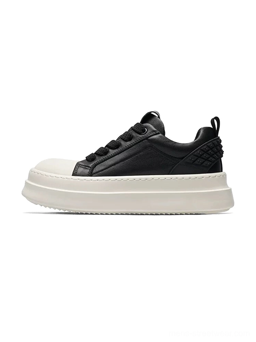 Black and white leather platform sneakers in left side profile with a thick white flatform sole and quilted heel panel
