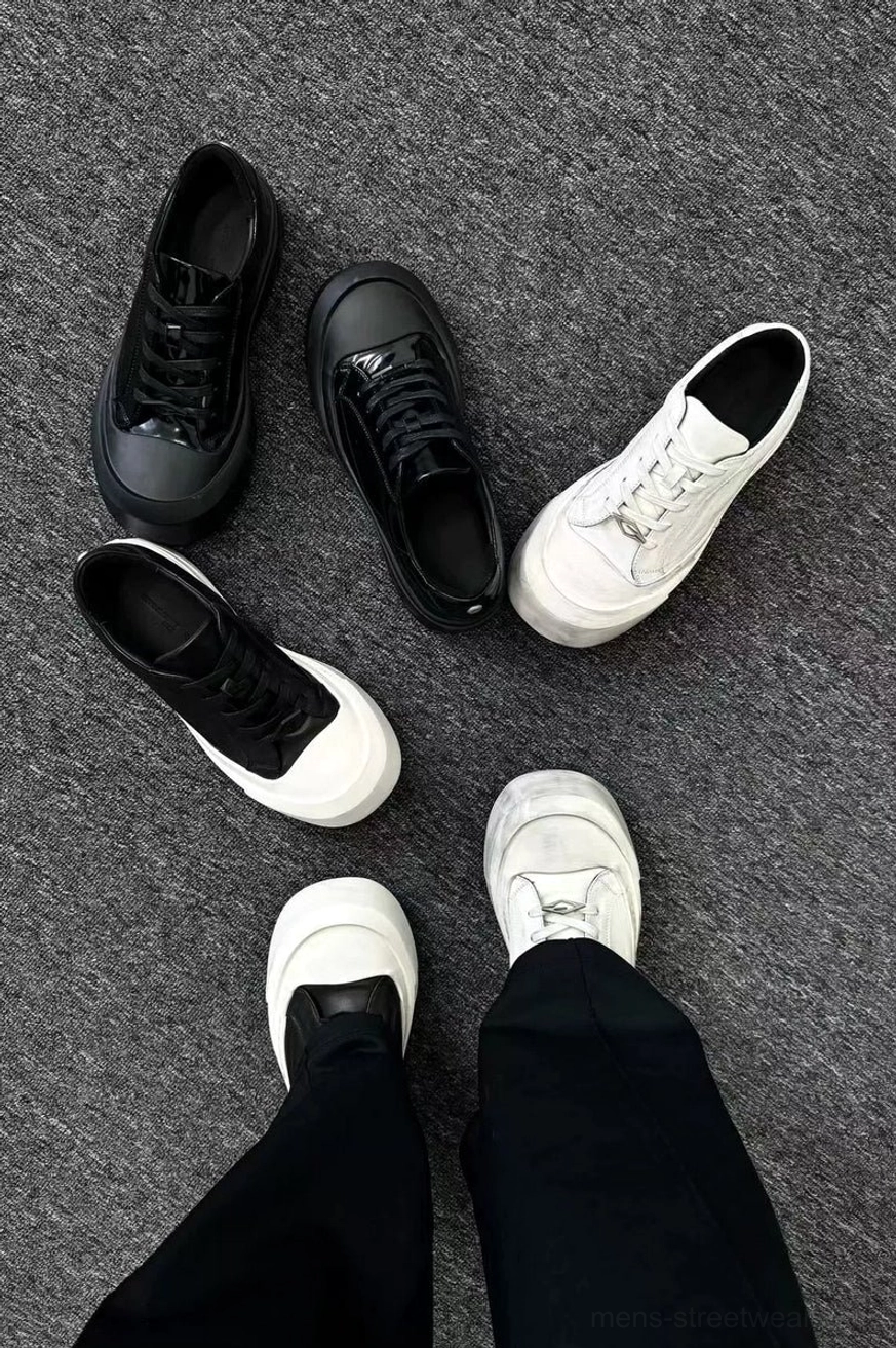 Top view of black and white leather toe cap platform sneakers styled with black tailored trousers for Korean streetwear fashion
