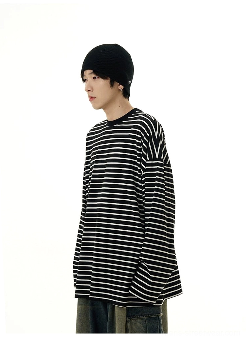 Upper body view of an oversized black and white striped crew neck tee with extra long sleeves