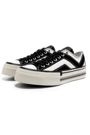 Black and white platform canvas sneakers with chevron side stripes shown in three-quarter front view on a white studio background