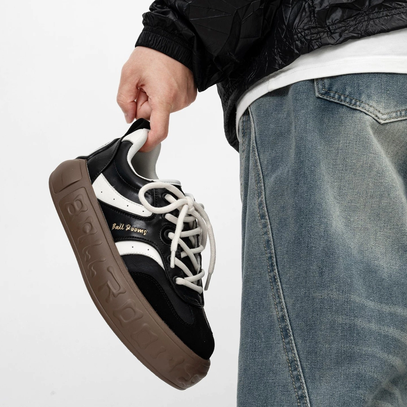 Black and white retro skate sneakers with contrast black side stripes black suede toe cap and thick gum rubber outsole shown from an angled side view