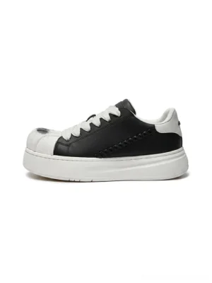 Black and white shell toe platform derby sneaker shown from the side on a white background with wide flat laces, woven side detailing, synthetic leather upper, and thick raised sole