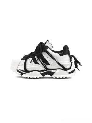 Black and white strapped chunky sneakers shown in a side profile with sculpted platform sole and layered streetwear strap details