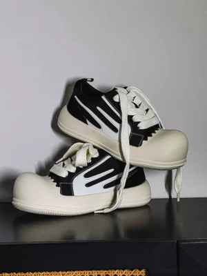 Black and white chunky platform streetwear sneakers with contrast side stripes oversized rubber toe cap and loose laces