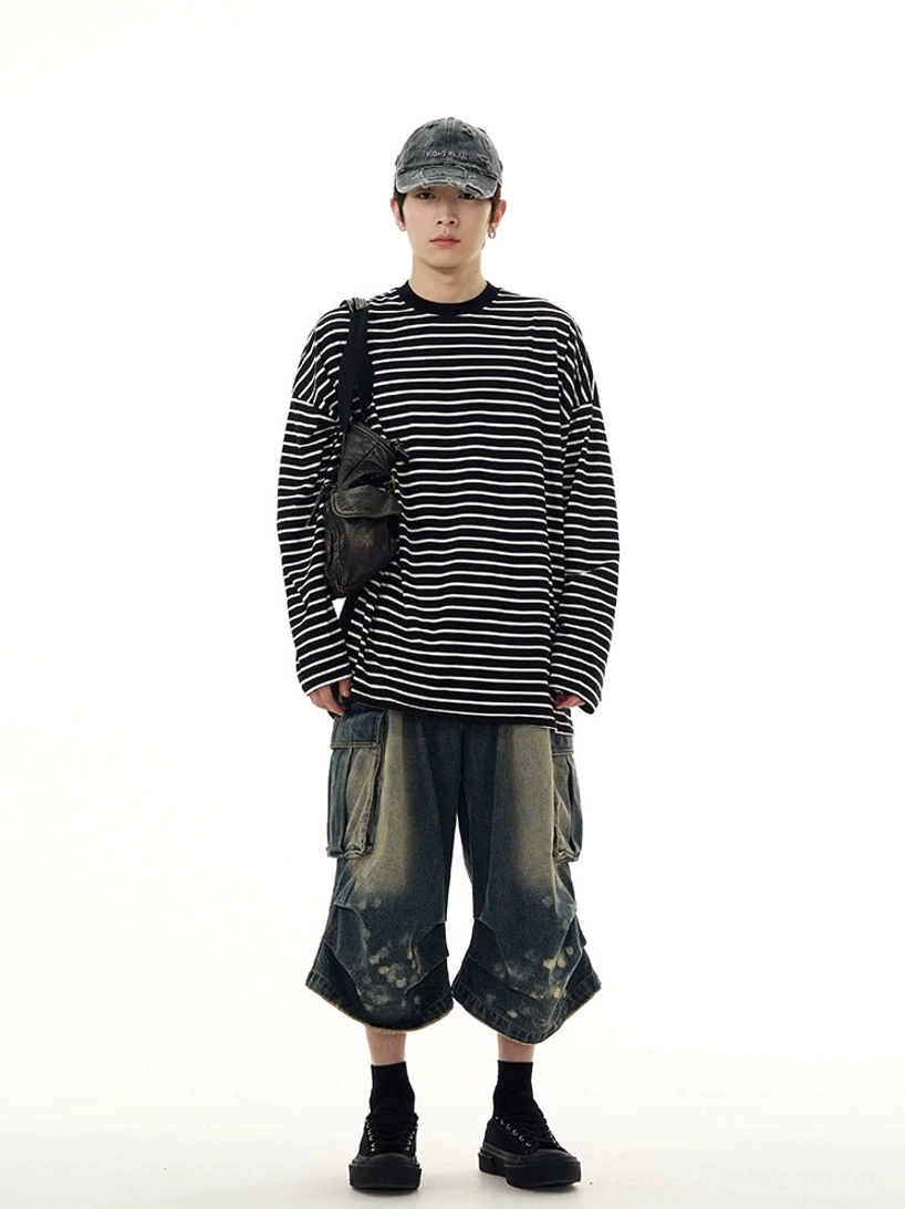 Full body styling of a black and white striped long sleeve streetwear tee with washed cargo denim shorts cap and crossbody bag