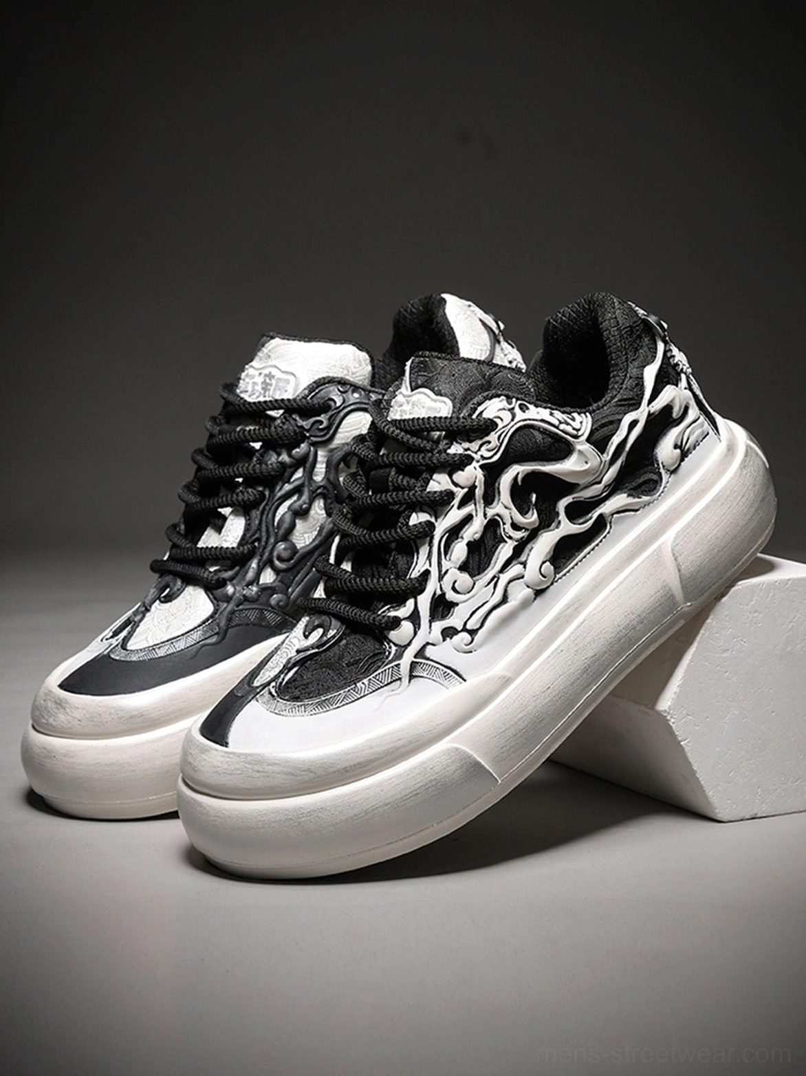 Pair of black white Tai Chi panda graphic platform sneakers displayed on white blocks with chunky soles and lace-up fronts
