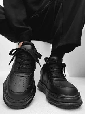 Black chunky platform casual sneakers with perforated toe box and sculpted wavy sole top view