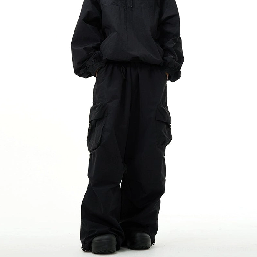 Black wide-leg cargo pants with practical flap pockets and relaxed techwear-inspired silhouette
