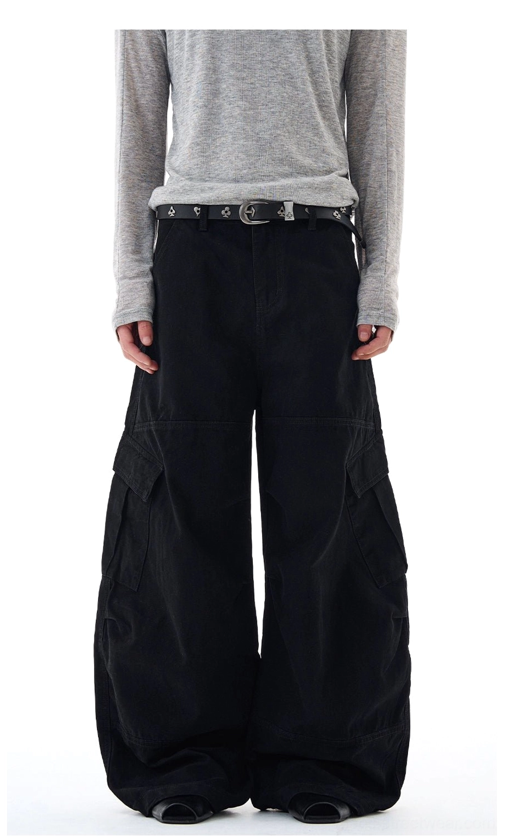 Black wide-leg cargo pants shown from the front with hands in pockets, matte woven cotton texture, and oversized streetwear fit