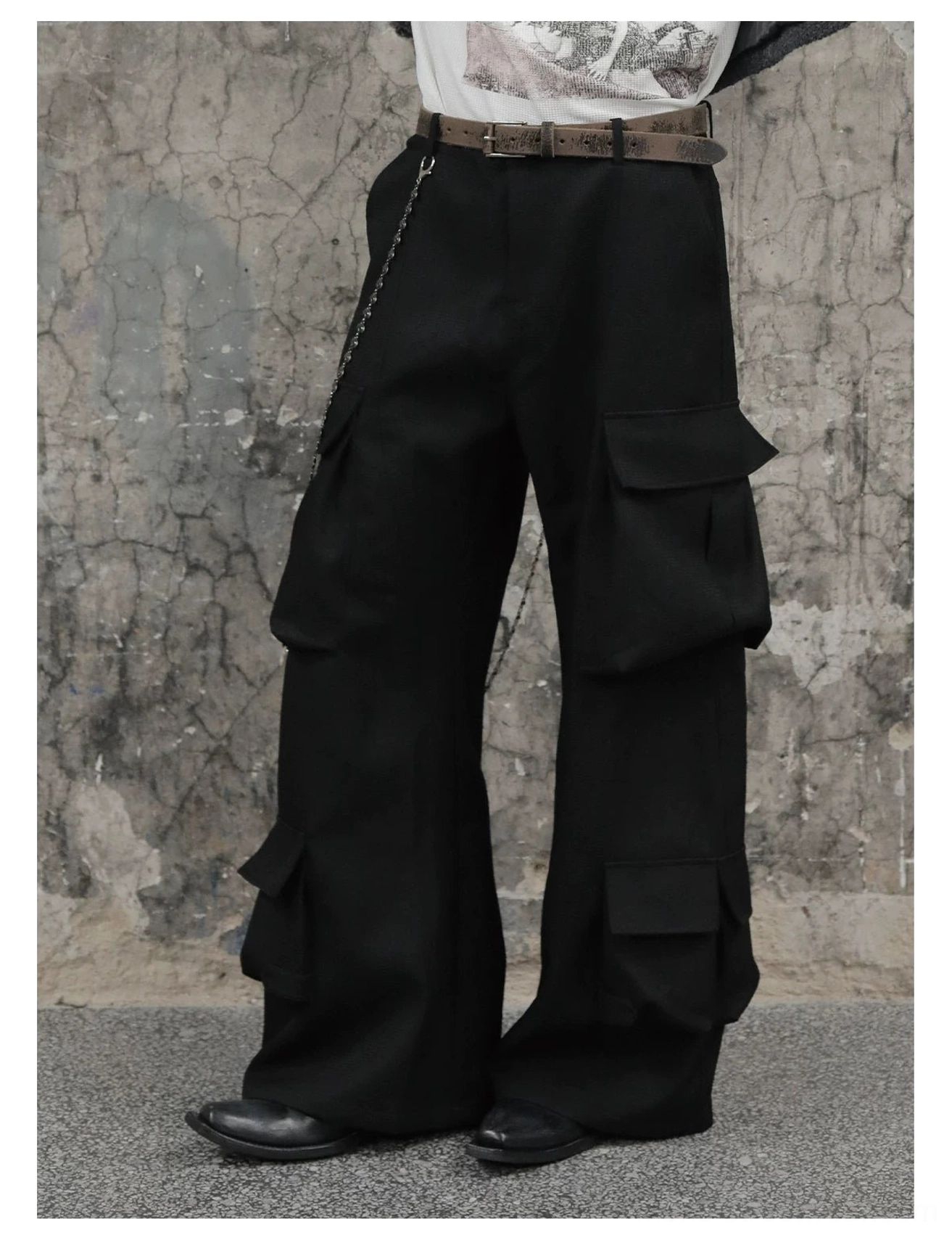 Black wide-leg cargo trousers paired with a brown leather belt, waist chain, and black leather shoes