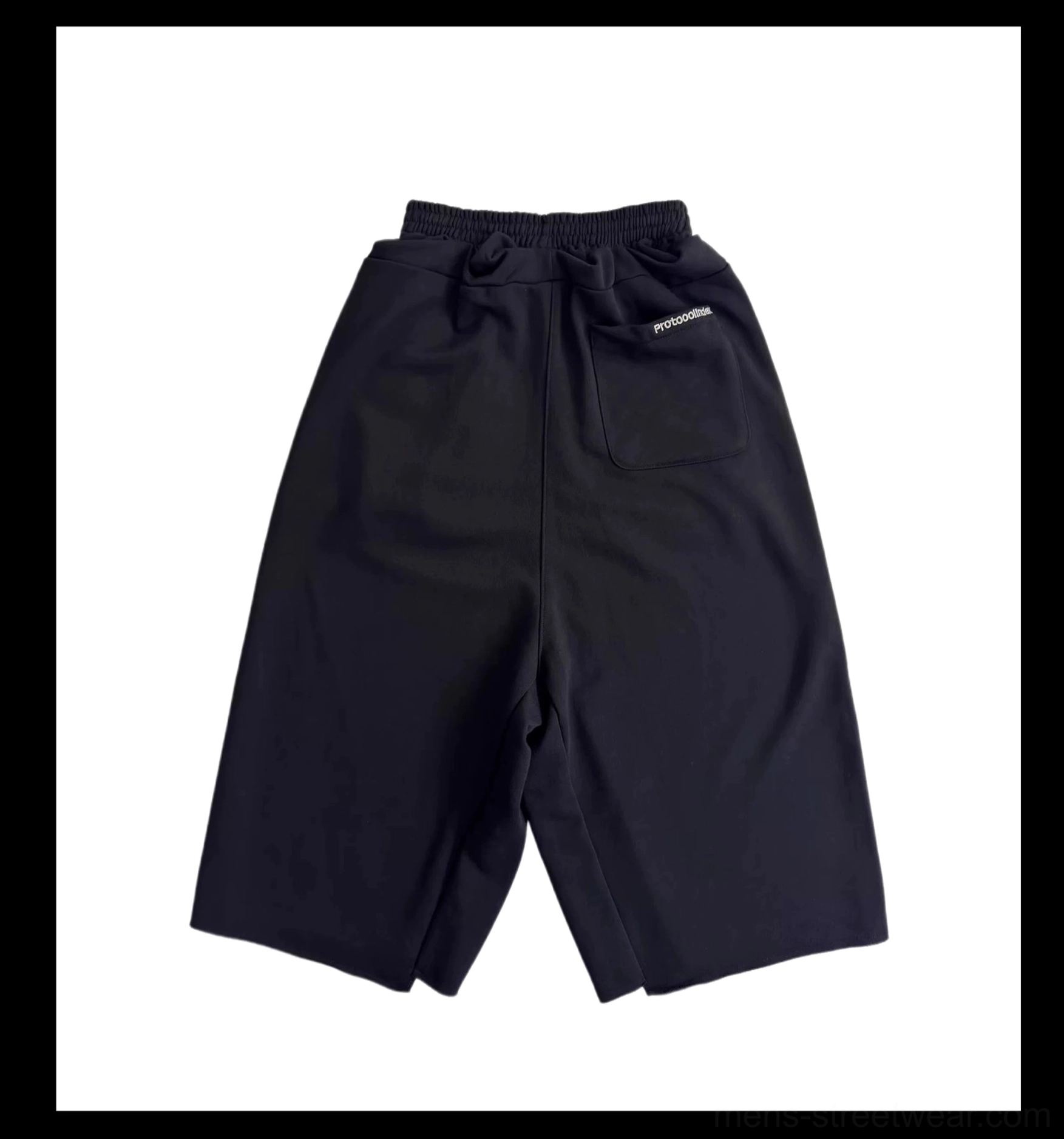 Flat lay rear view of solid black wide-leg cropped court shorts with elasticated waistband, clean back pocket, and relaxed streetwear fit