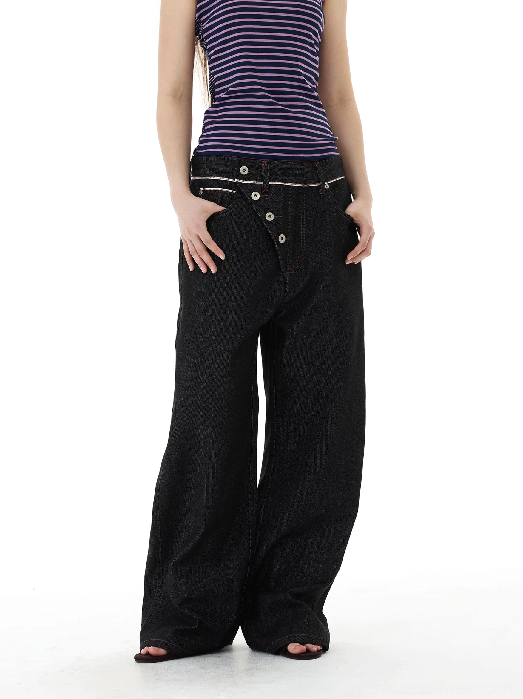 Black denim wide-leg jeans styled with a striped tank top, multi-button asymmetric waist, and contrast stitched waistband